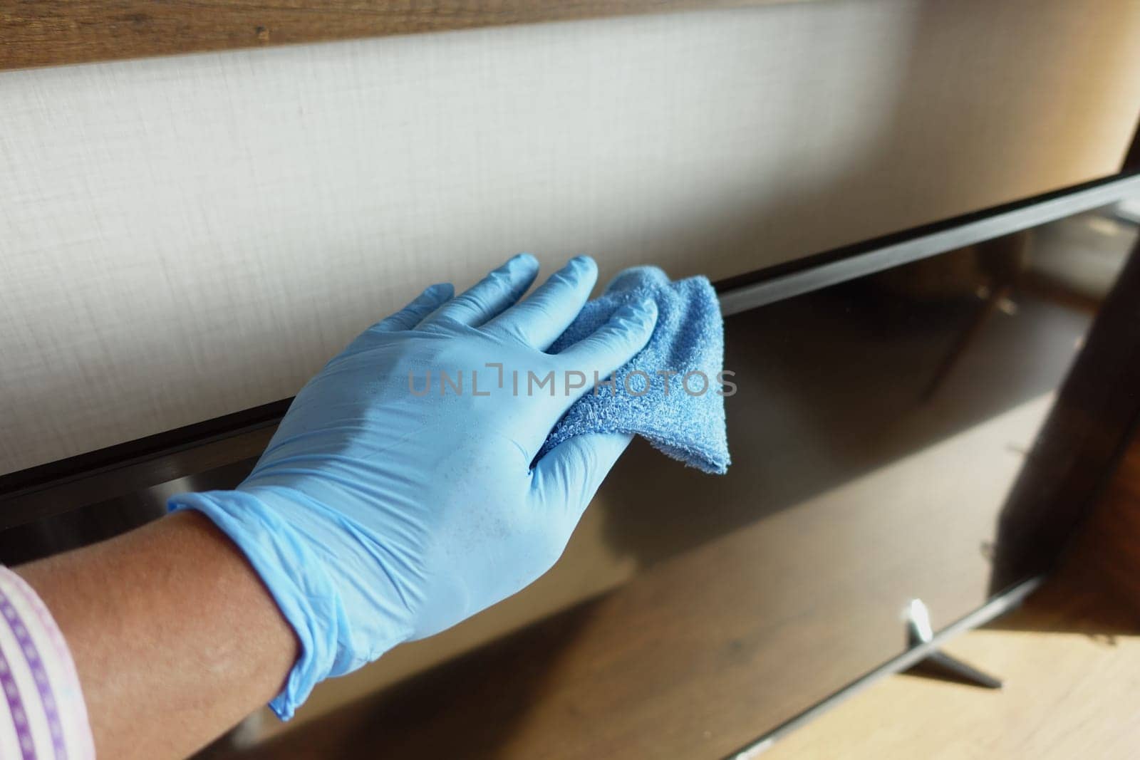 a man wipes dust from a plasma TV.