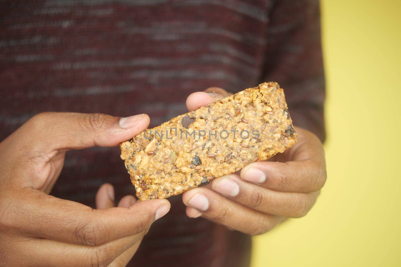 holding a oats protein bar ,