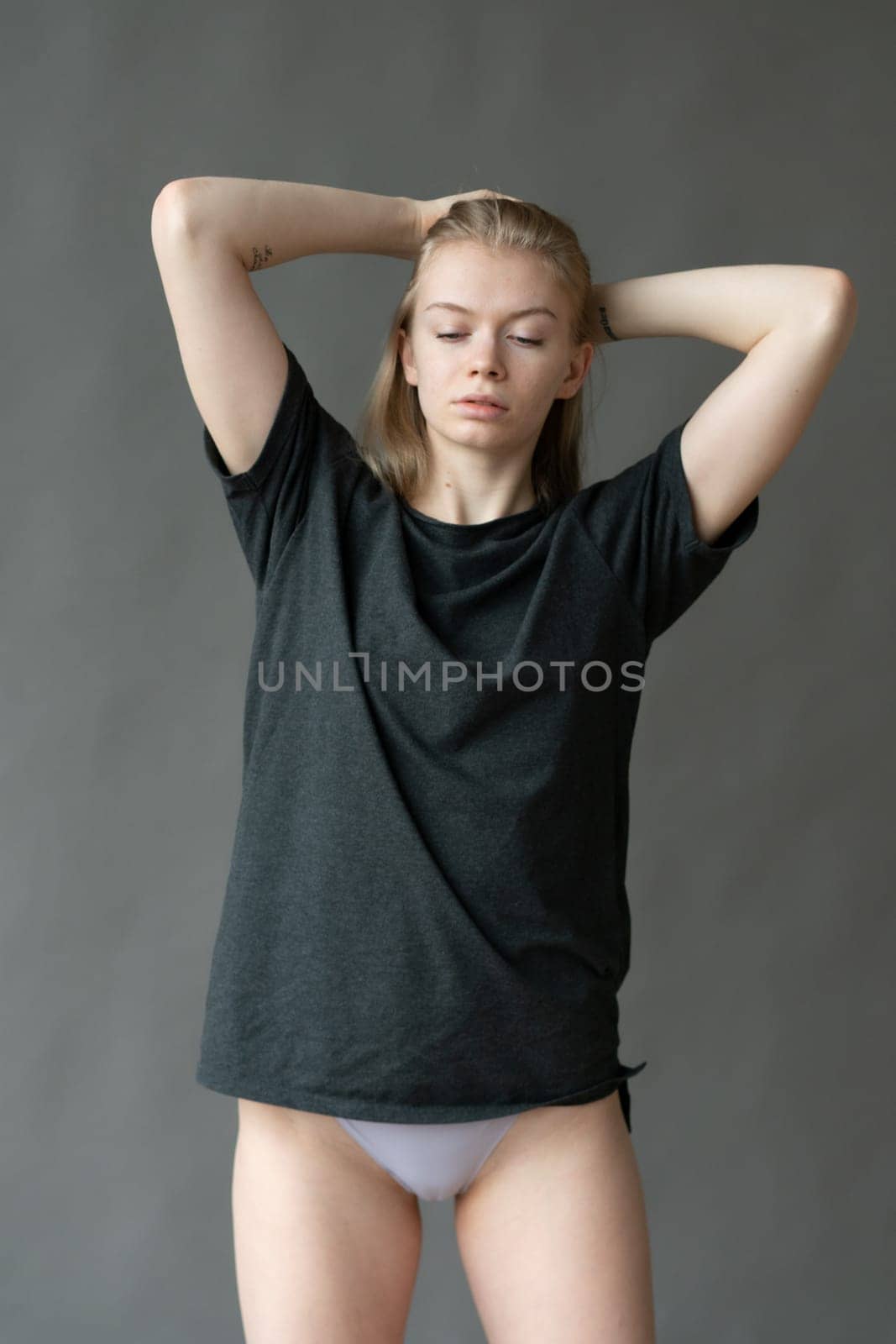 young beautiful woman posing in gray lingerie in studio