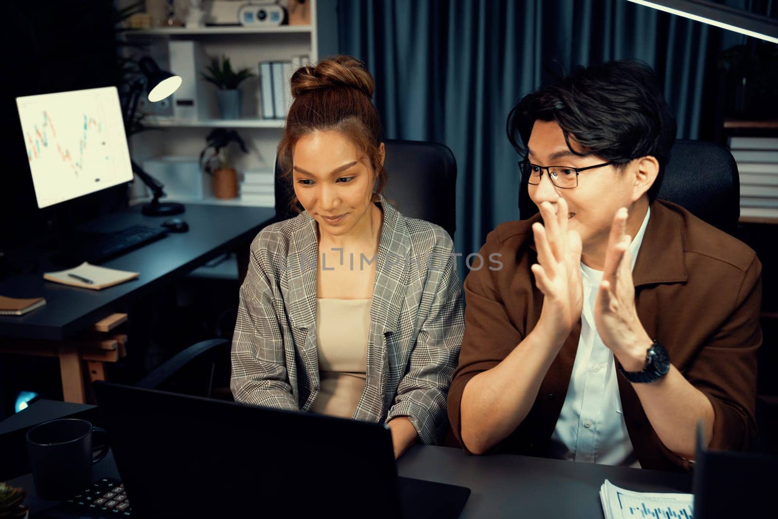 Smiling businesswoman trader with partner discussing on stock market trading exchange in casual suit, getting highest profit trading value financial technology investment at office at night. Infobahn.