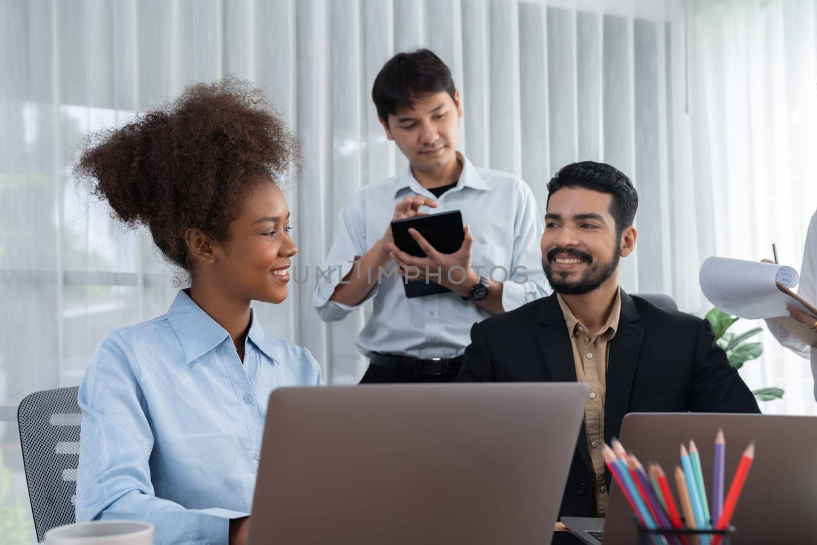 Happy diverse business people work together, discussing in corporate office. Professional and diversity teamwork discuss business plan on desk with laptop. Modern multicultural office worker. Concord