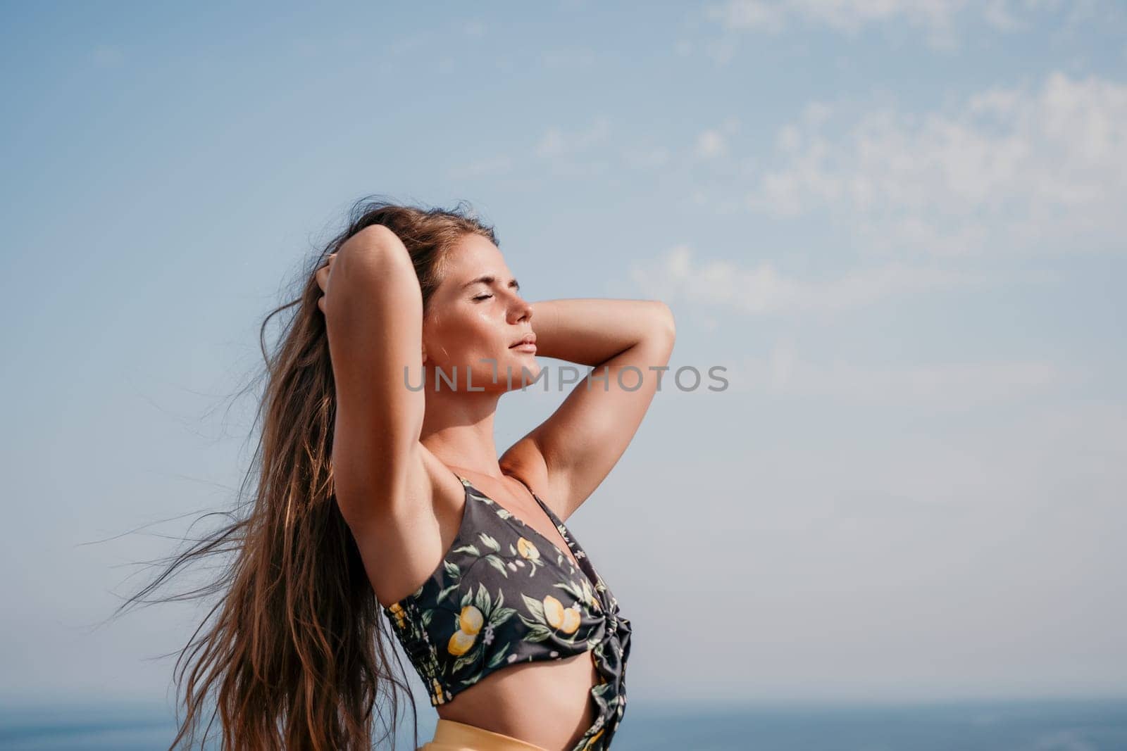 Woman travel sea. Happy tourist taking picture outdoors for memories. Woman traveler looks at the edge of the cliff on the sea bay of mountains, sharing travel adventure journey.