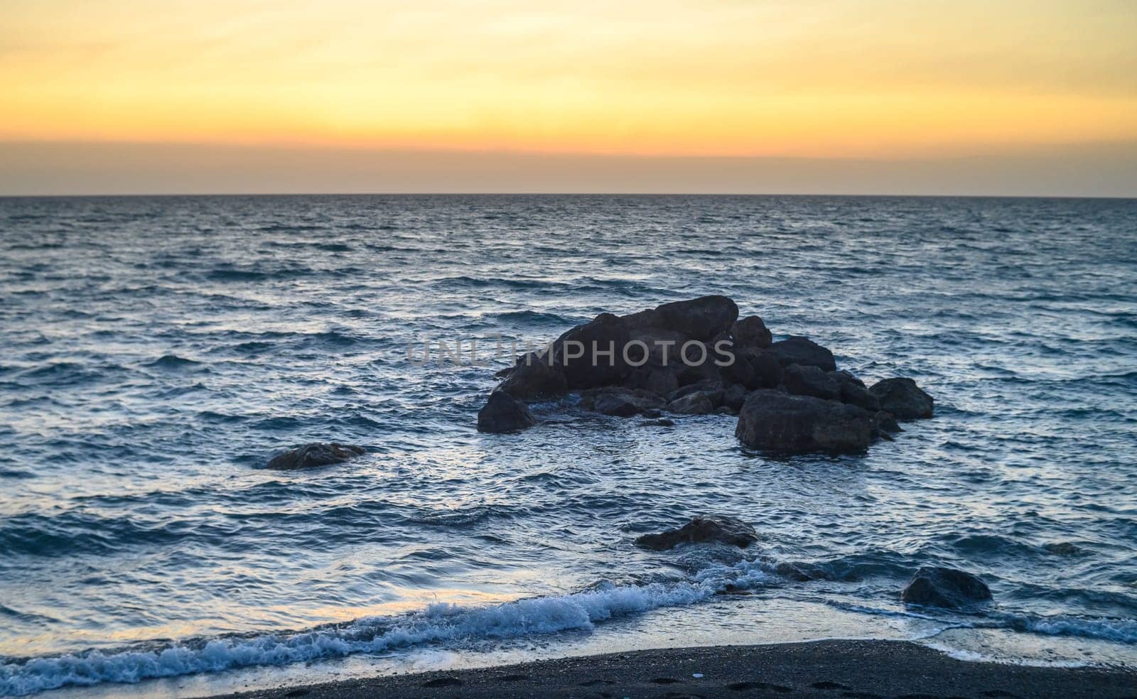 sunset view of stones in the Mediterranean sea near the beach of Cyprus by Mixa74