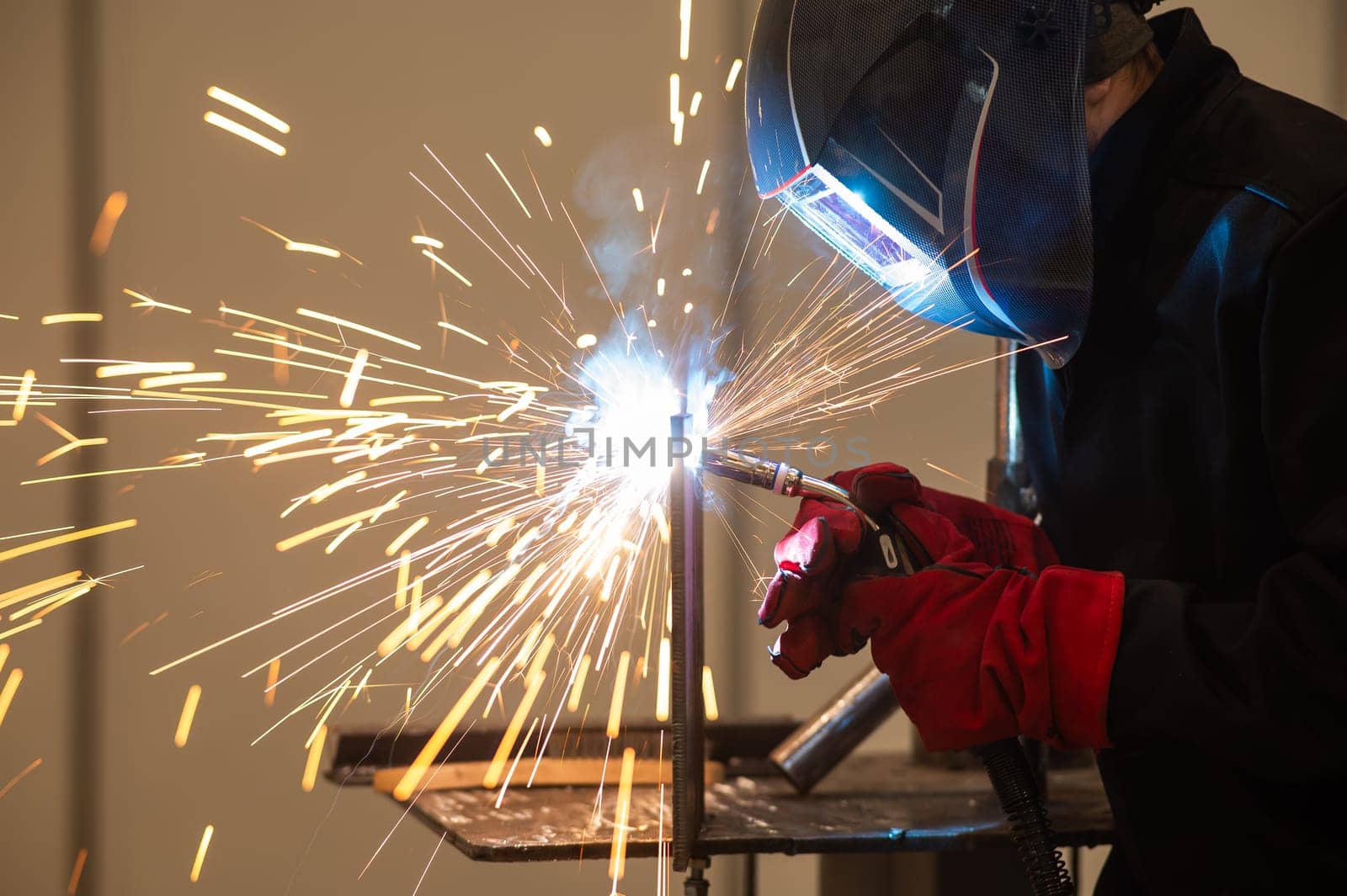 A man learns the craft of welding on a sample