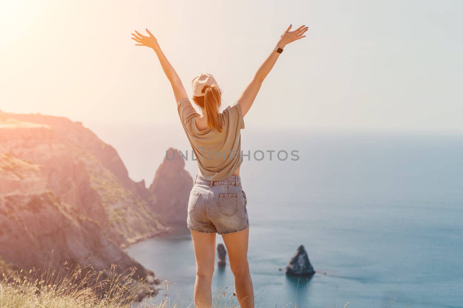 Woman travel sea. Happy carefree sensual woman with long hair in black swimwear posing at sunset beach. Silhouette of young beautiful playful positive woman outdoor. Summer vacation and trip concept