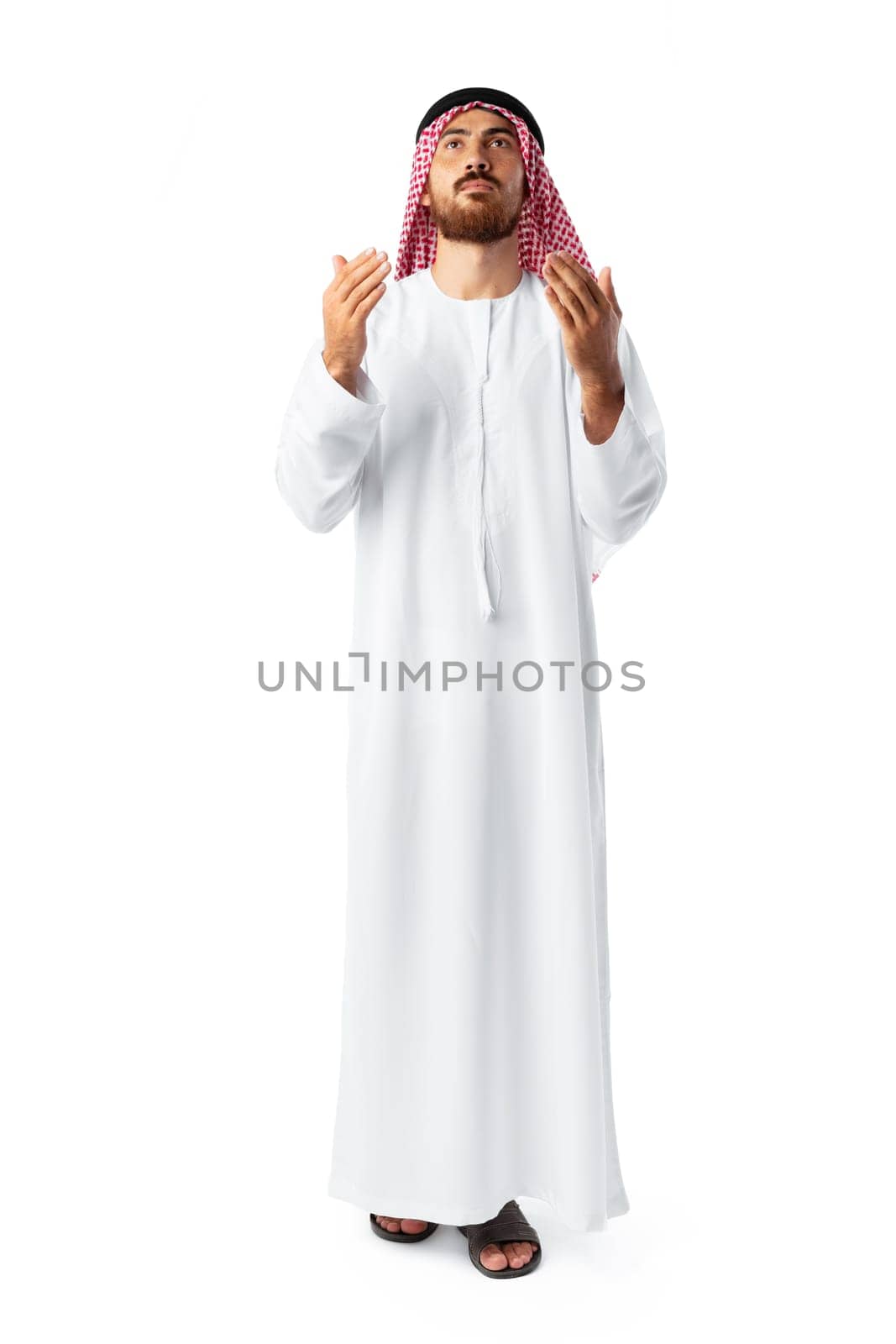 Young Arab man in traditional clothing praying isolated on white background