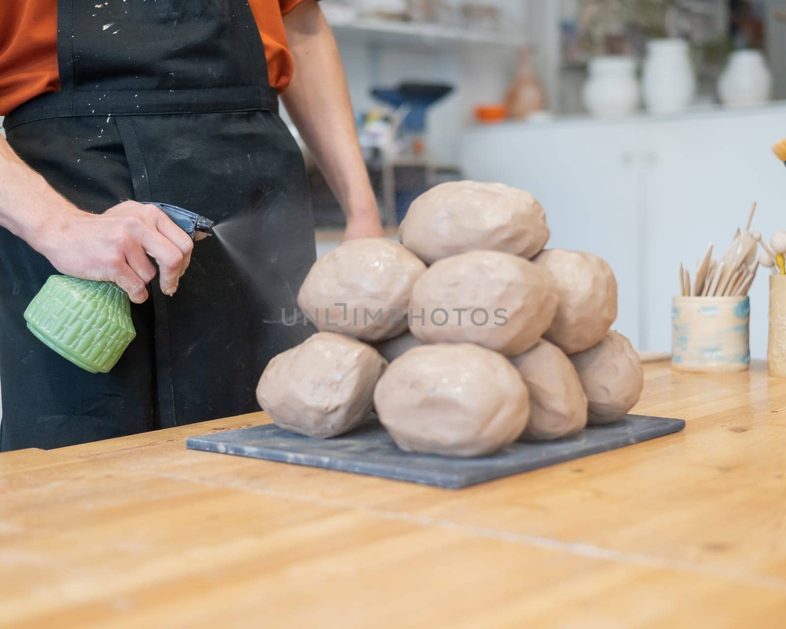 The potter wets the clay before using it in the workshop