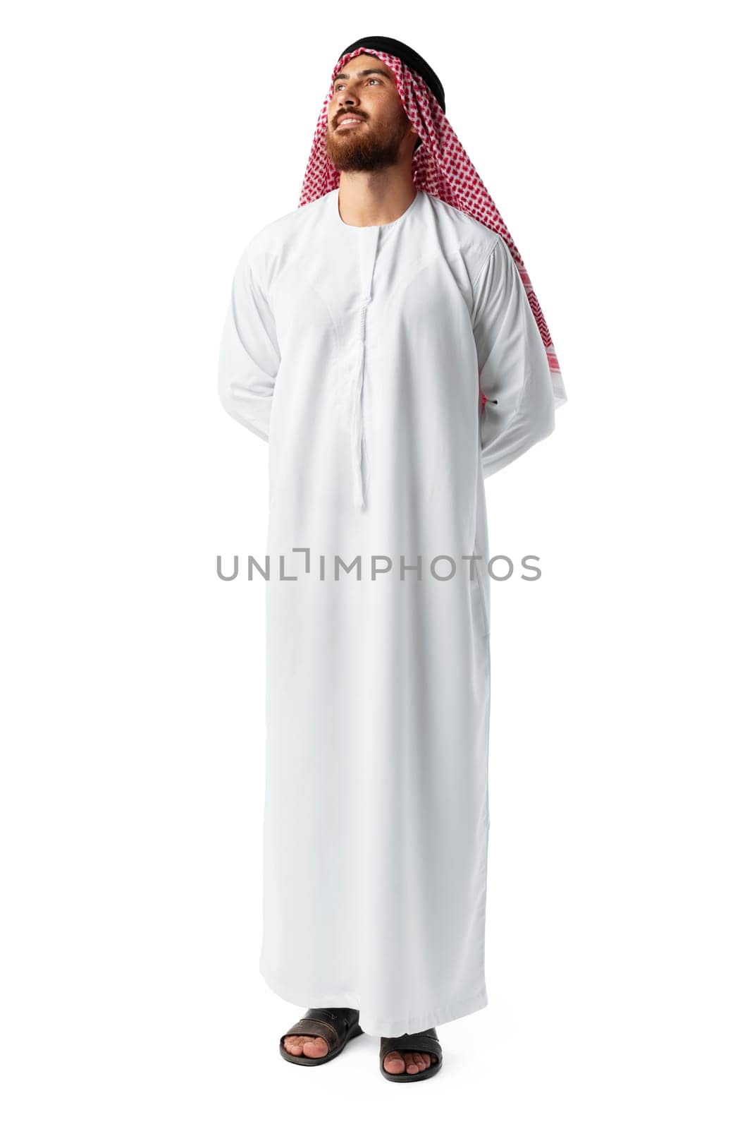 Smiling arab man while standing in an isolated white studio