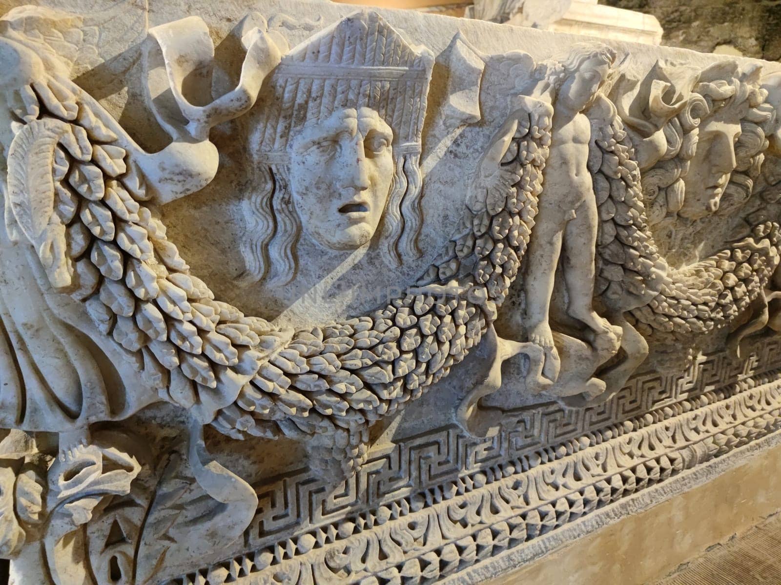 Marble sarcophagus with bas-reliefs of human faces and cherubs in the ancient city of Hierapolis, Pamukkale in Turkey.