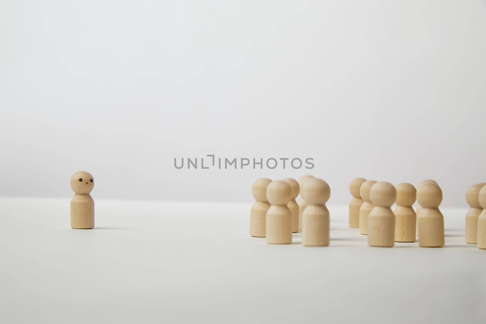 Wooden figurines with a leader and group with partial focus. The confrontation between the head and the employees. Outcast, different, different. Bullying at school, at work