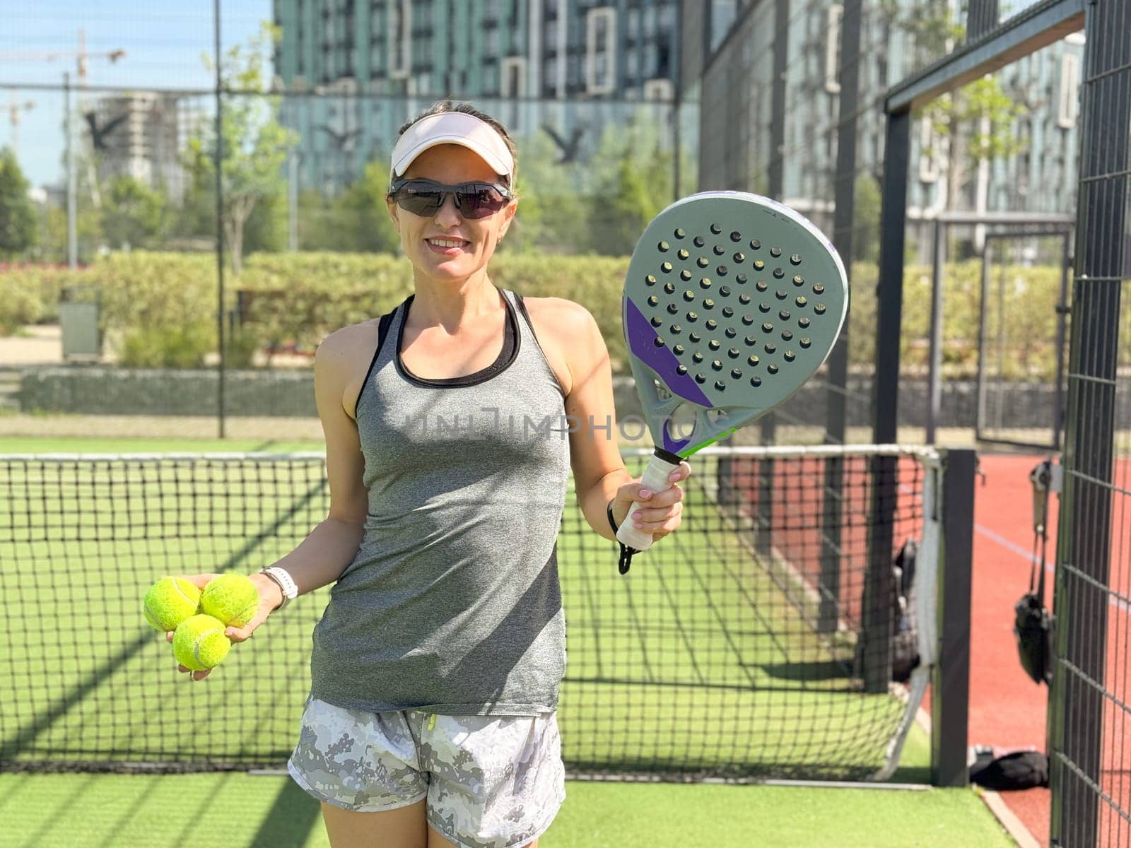 Happy female paddle tennis player during practice on outdoor court. Copy space. High quality photo