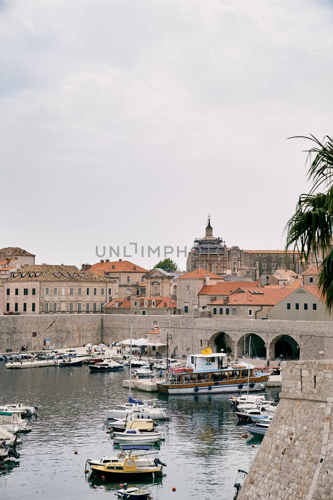 Boats stand on the pier near the fortress walls of the old town of Dubrovnik. Croatia. High quality photo