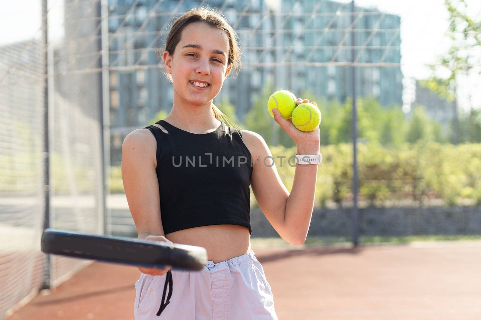 Padel tennis player with racket and ball in hands. Girl athlete with paddle racket on court outdoors. Sport concept. Download a high quality photo for the design of a sports app or web site. High quality photo