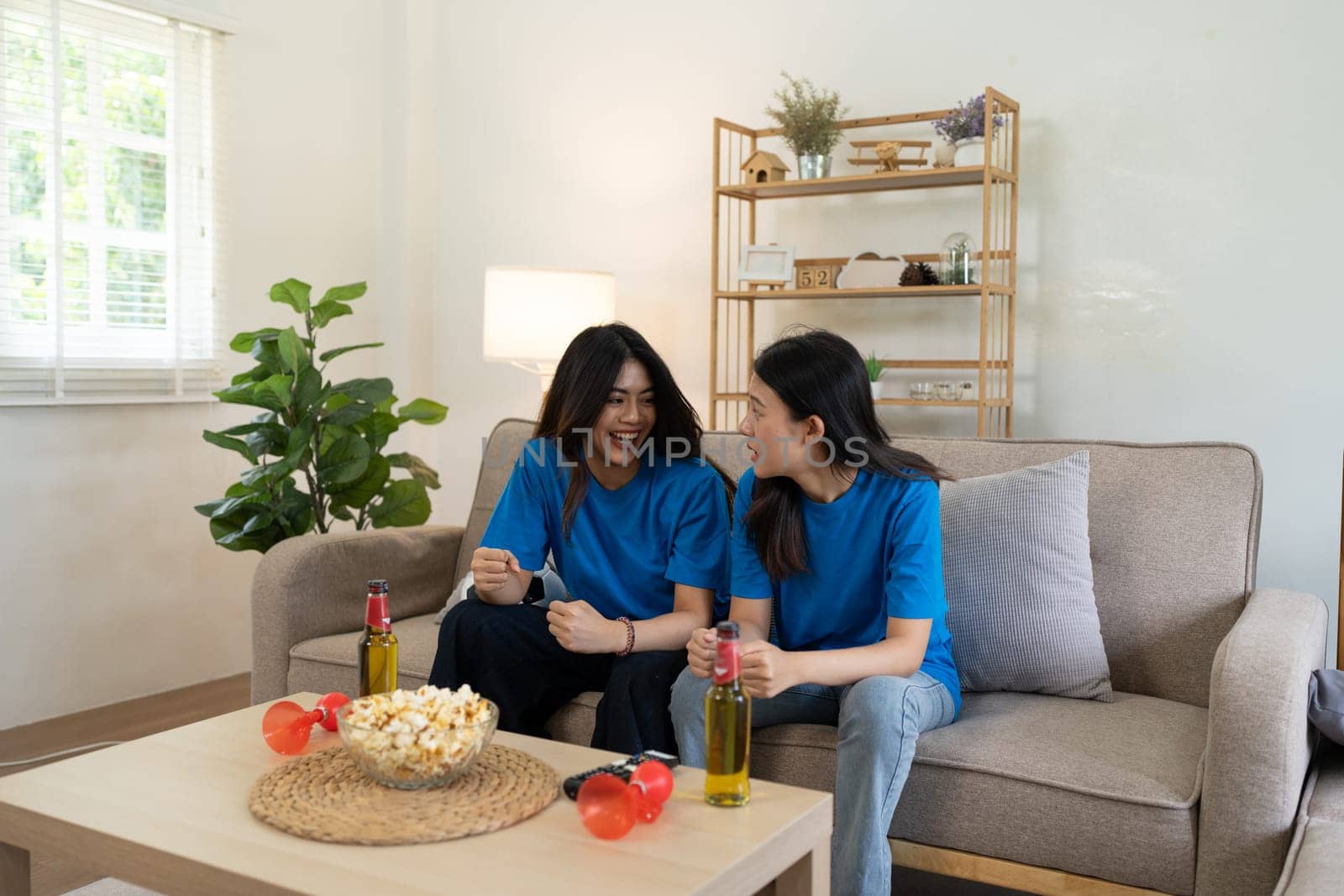 LGBT Soccer fans emotionally watching game in the living room.