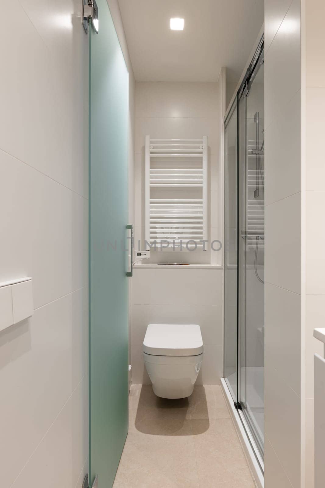 Bright and modern minimalist bathroom featuring a wall-mounted toilet, glass shower, and clean lines. Ideal for contemporary home interior design.