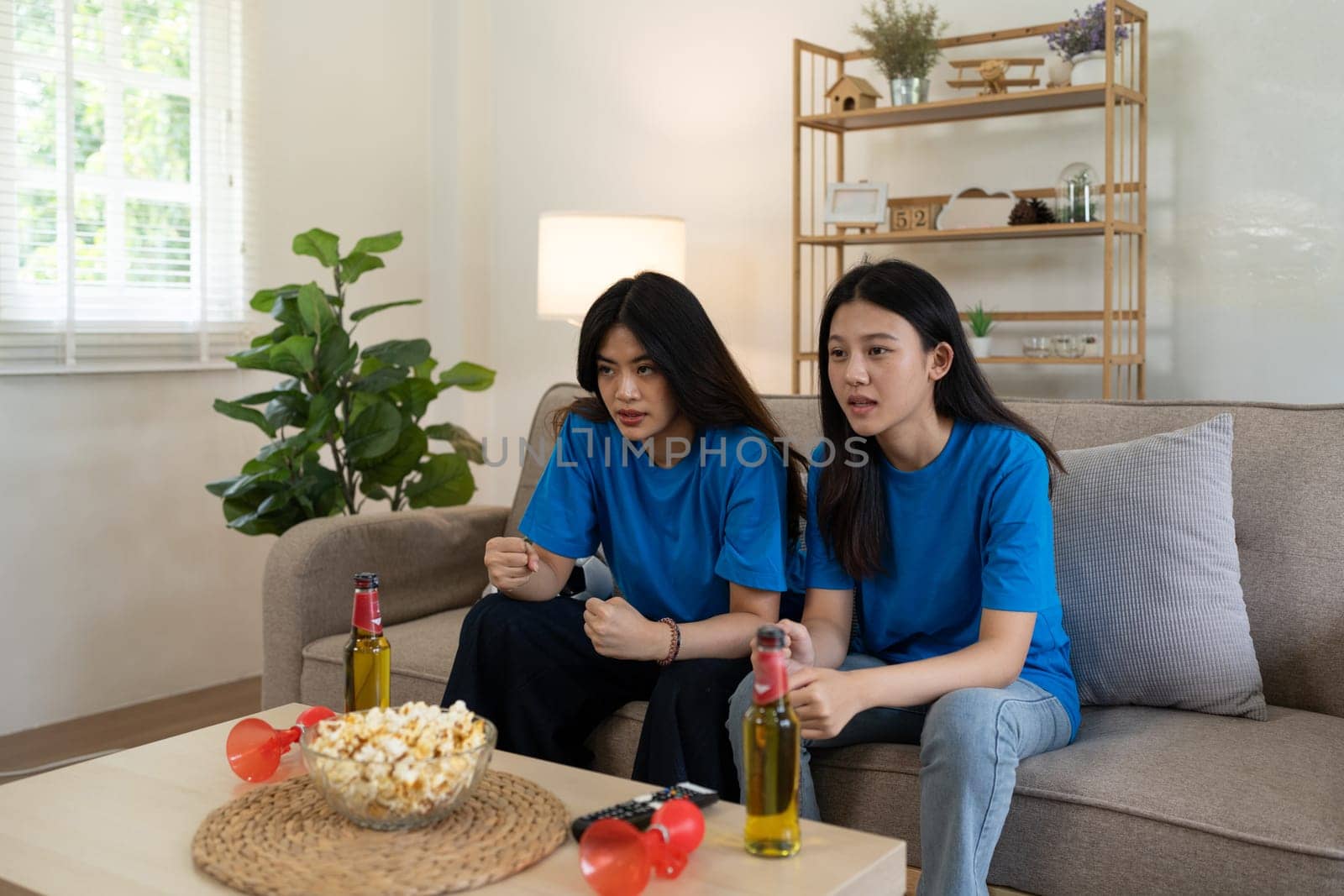 LGBT Soccer fans emotionally watching game in the living room.