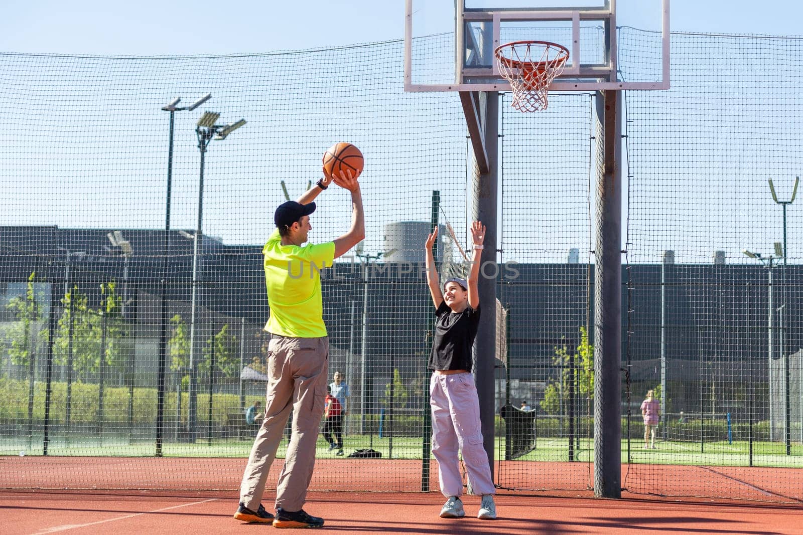 father and daughter playing basketball together on playground. High quality photo