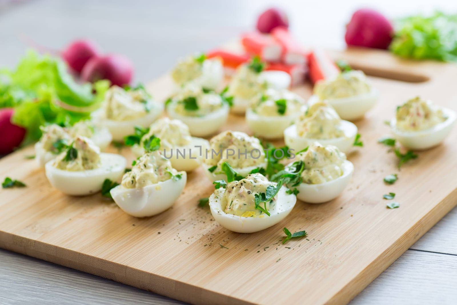 stuffed eggs, deviled eggs on a wooden table .