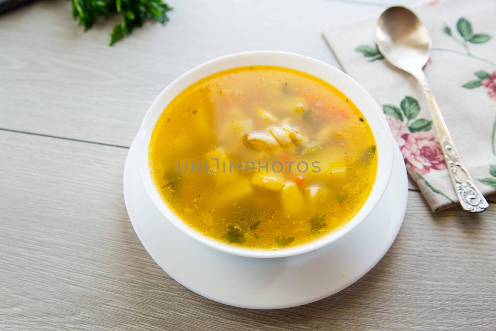 Homemade chicken vegetable soup on rustic wooden background .