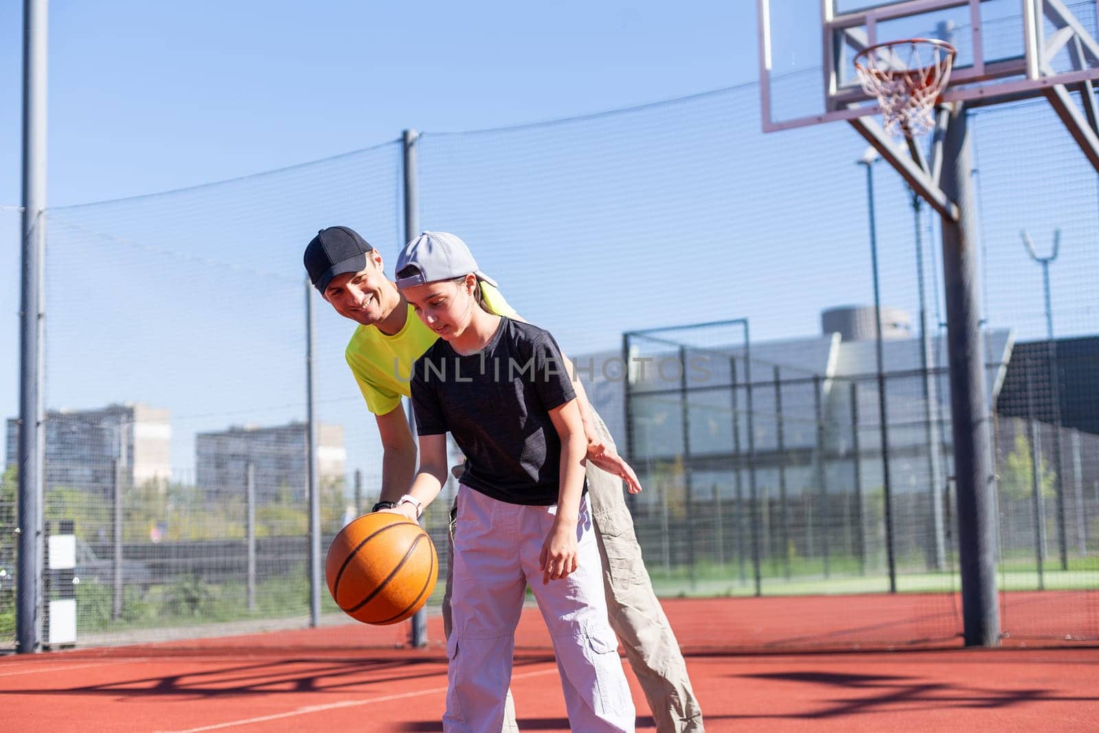 Concept of sports, hobbies and healthy lifestyle. Young people playing basketball on playground outdoors. High quality photo