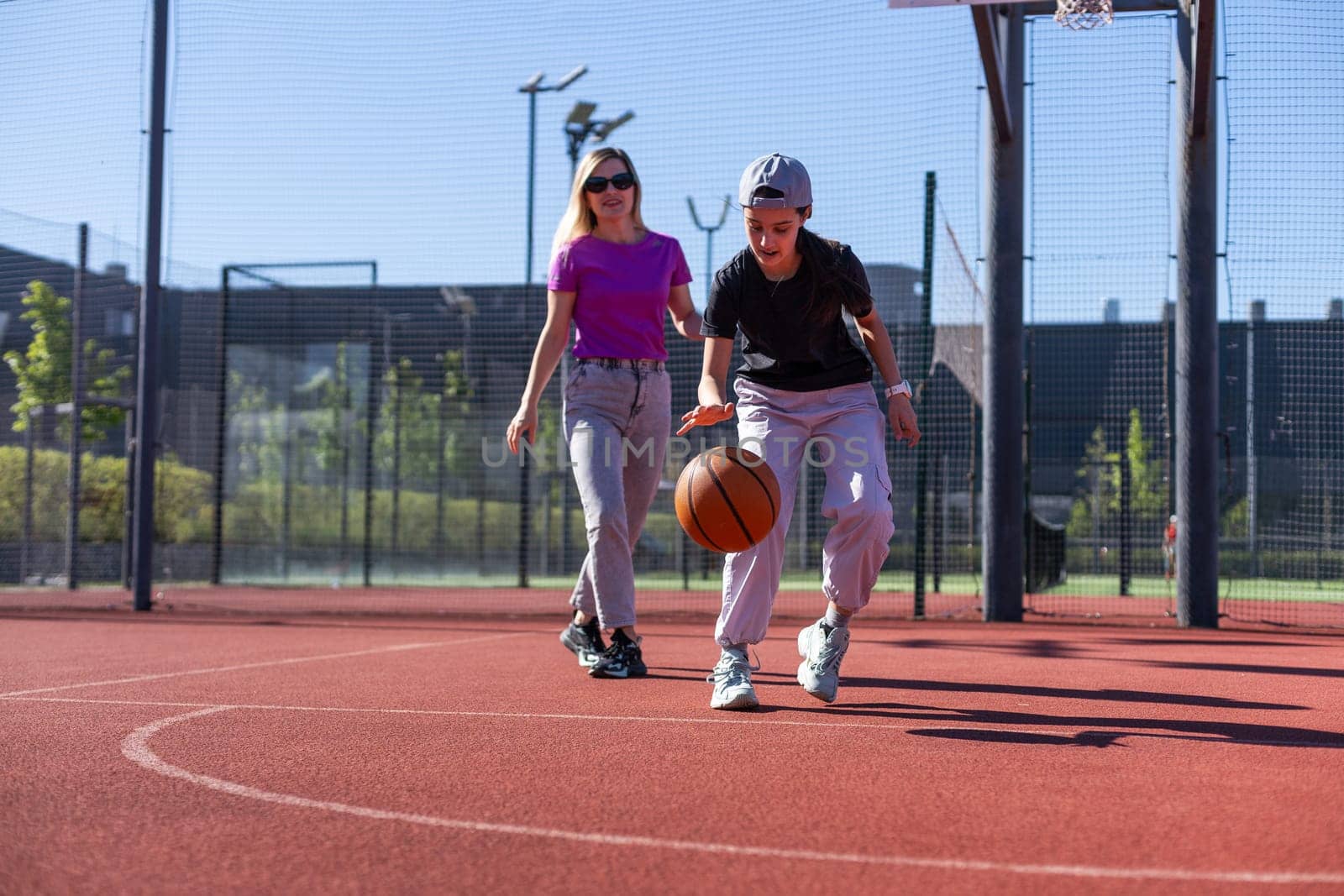mother and daughter play basketball on a beautiful sunny day. High quality photo