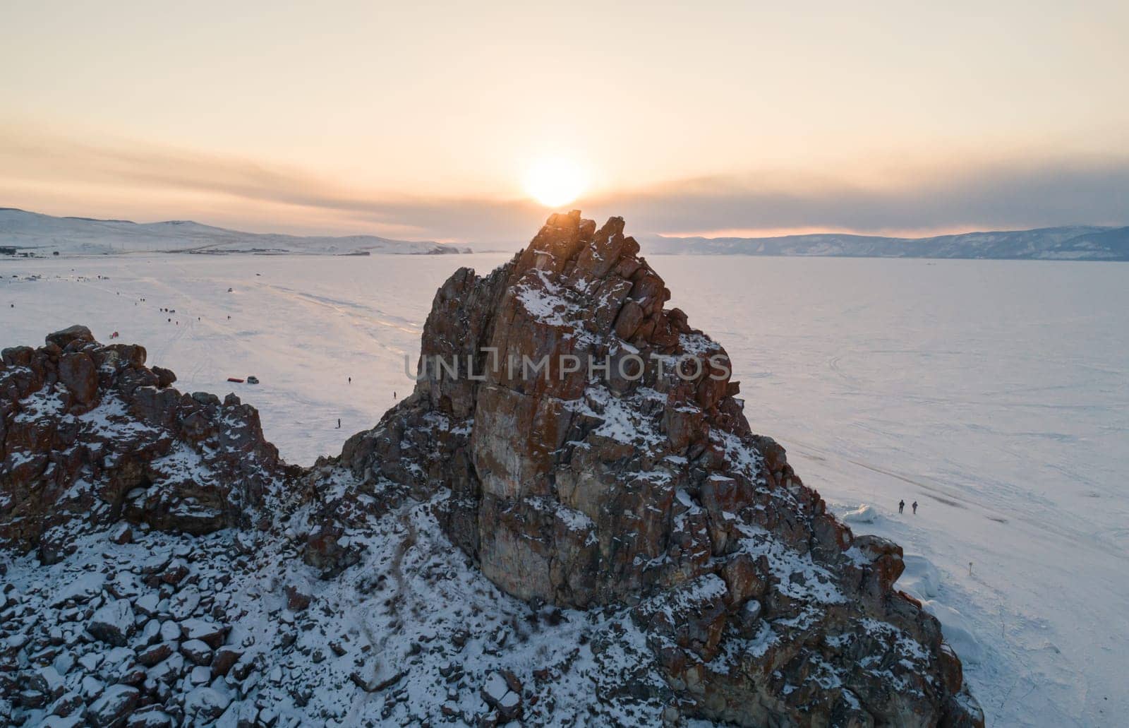 Aerial shot of Shamanka rock and Cape Burkhan on Olkhon. Beautiful view on frozen Baikal. Panoramic winter landscape. Popular touristic destination by Busker