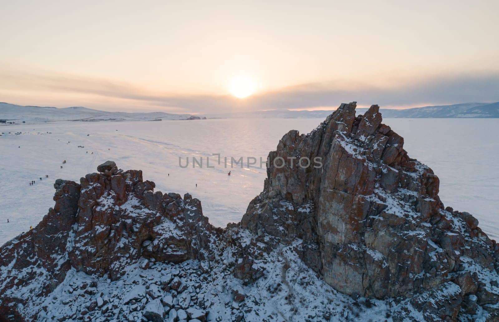 Aerial shot of Shamanka rock and Cape Burkhan on Olkhon. Beautiful view on frozen Baikal. Panoramic winter landscape. Popular touristic destination