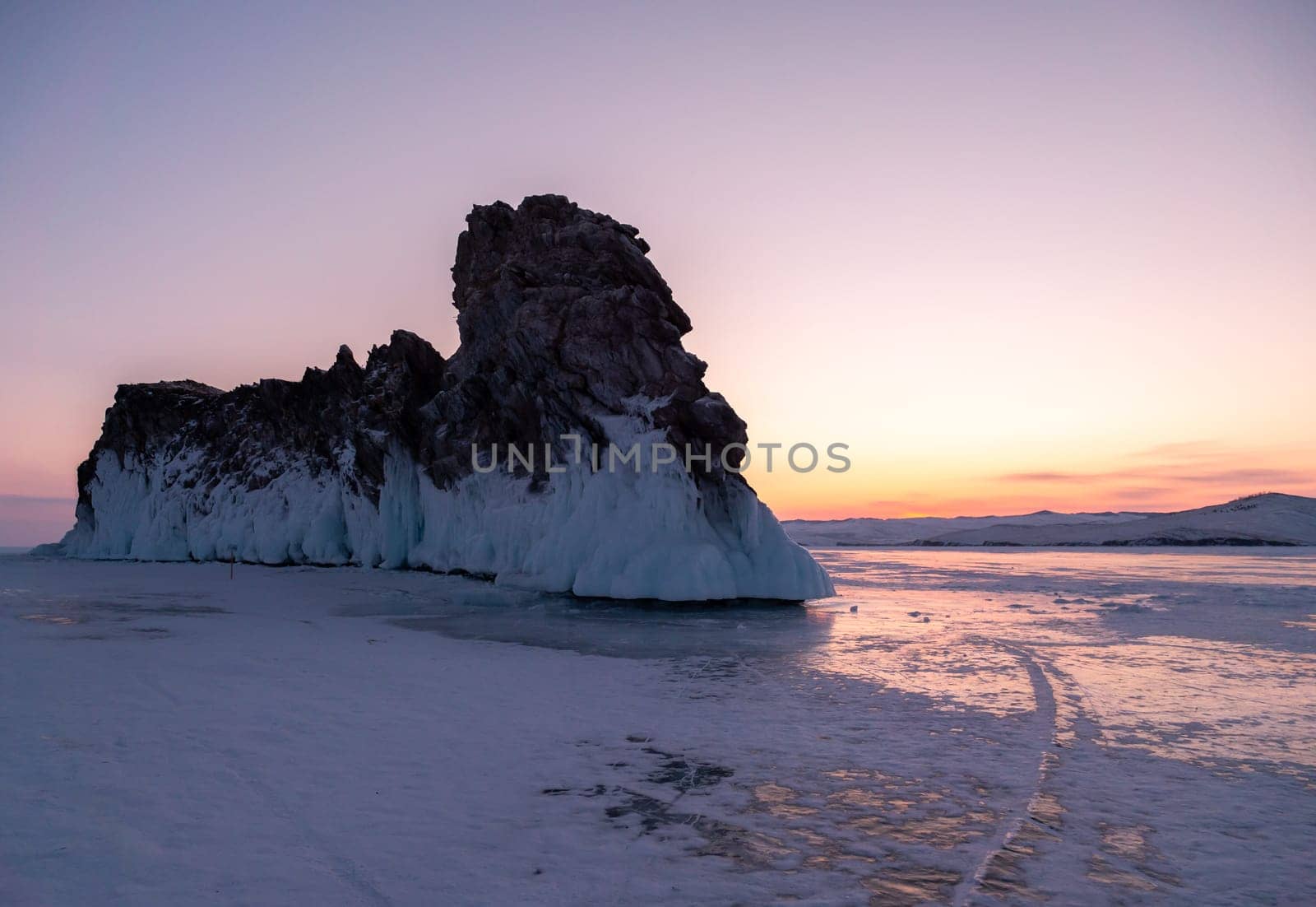 Ogoy island on winter Baikal lake. Winter scenery of Dragon Tail Rock on Ogoy island during sunrise at Lake Baikal. by Busker