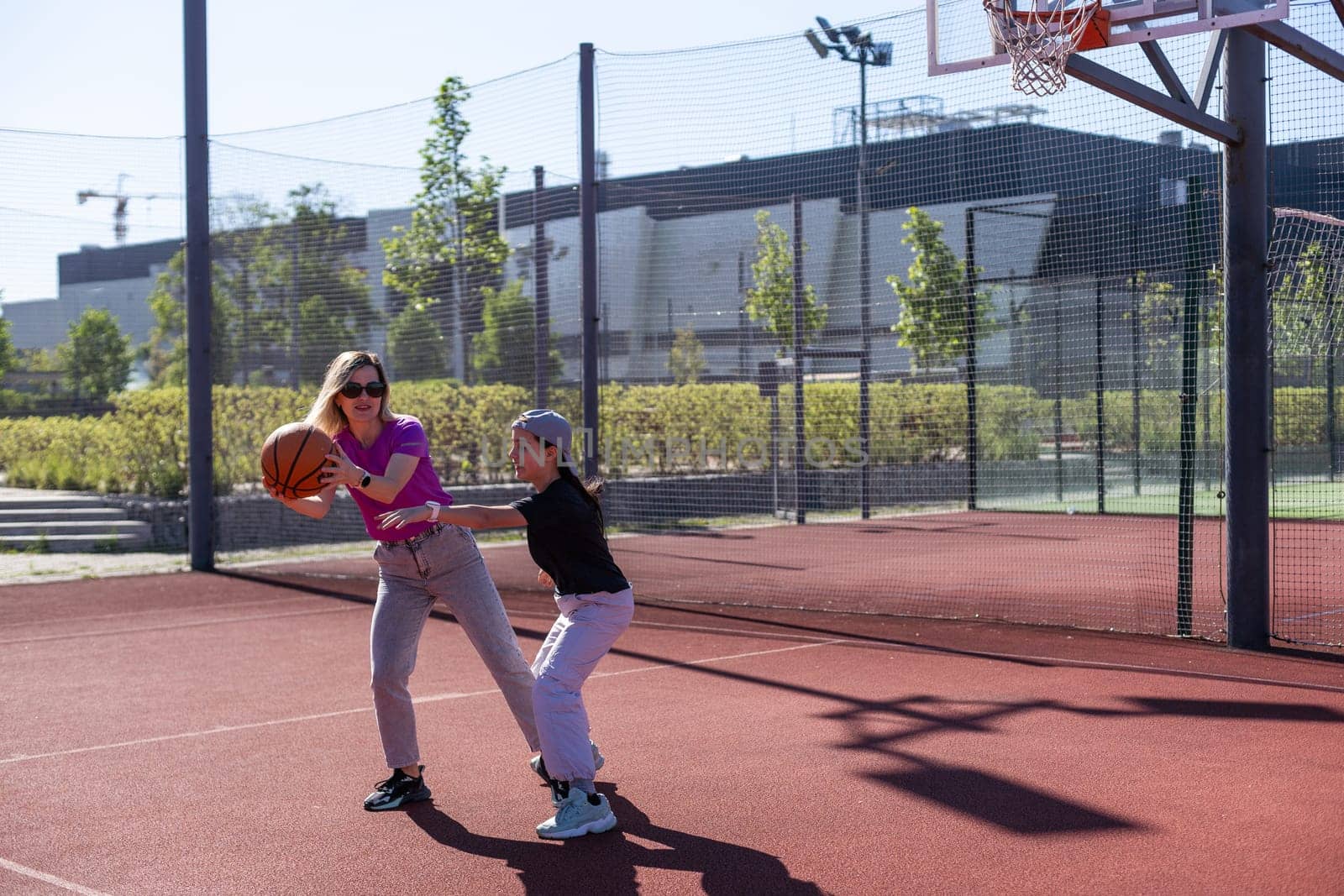 A Happy mother and child daughter outside at basketball court. High quality photo