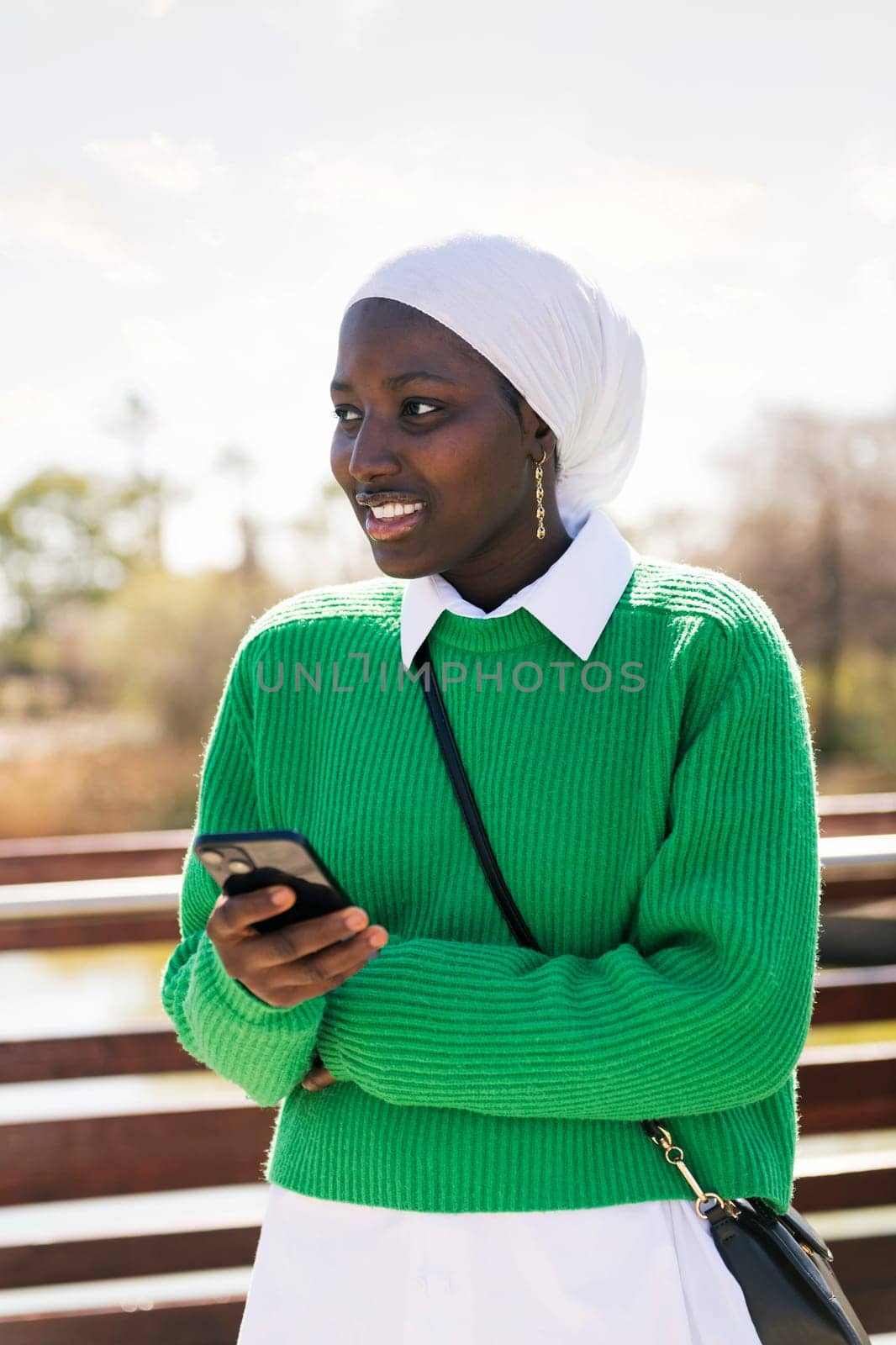 young african woman using mobile phone outdoors, concept of technology of communication and modern lifestyle