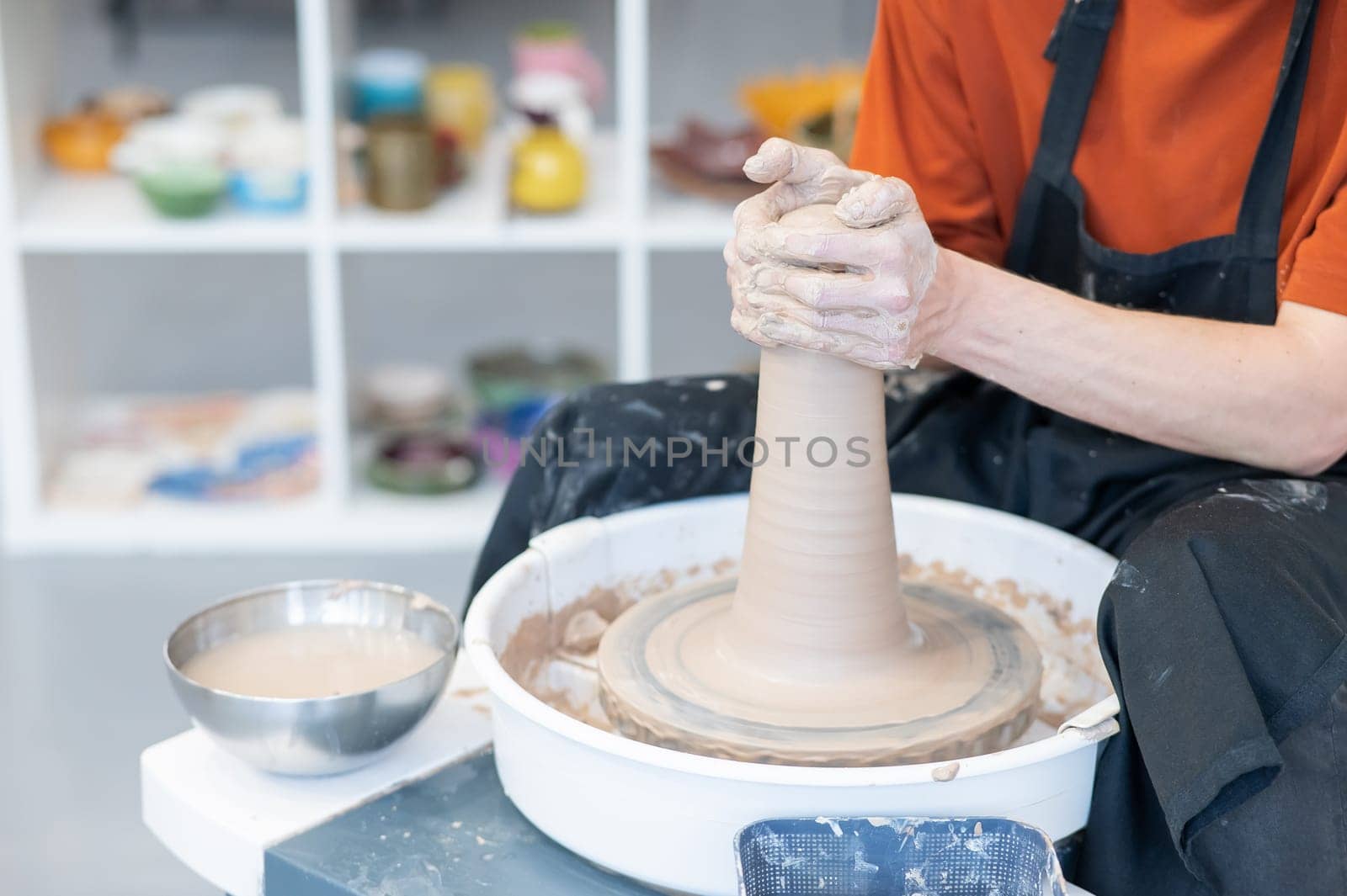 Close-up of a potter's hands working on a pottery wheel