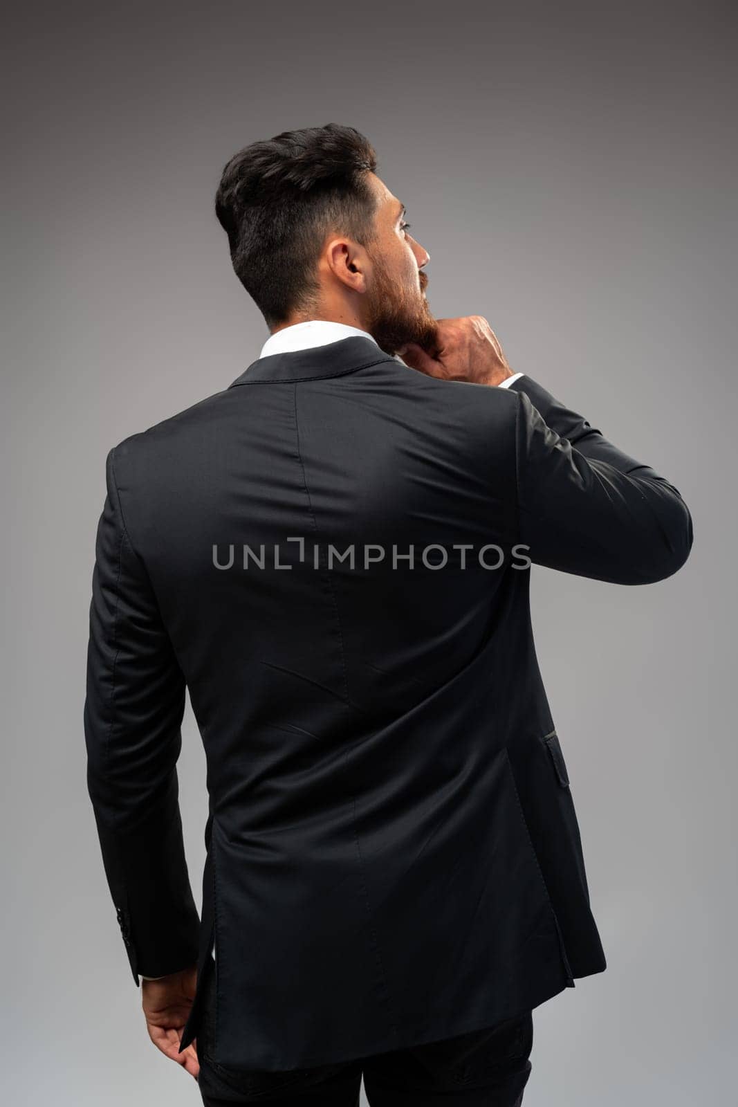 Studuo shot of thinking businessman standing over gray background close up