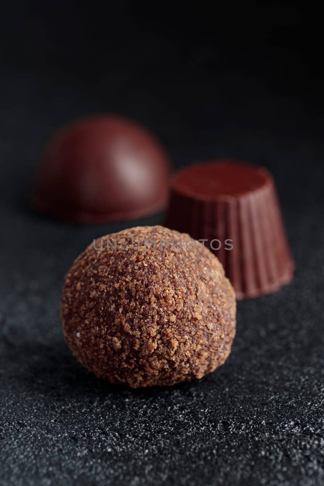 Premium gourmet chocolate handmade truffles from confectionery, homemade dark chocolate candies on black background