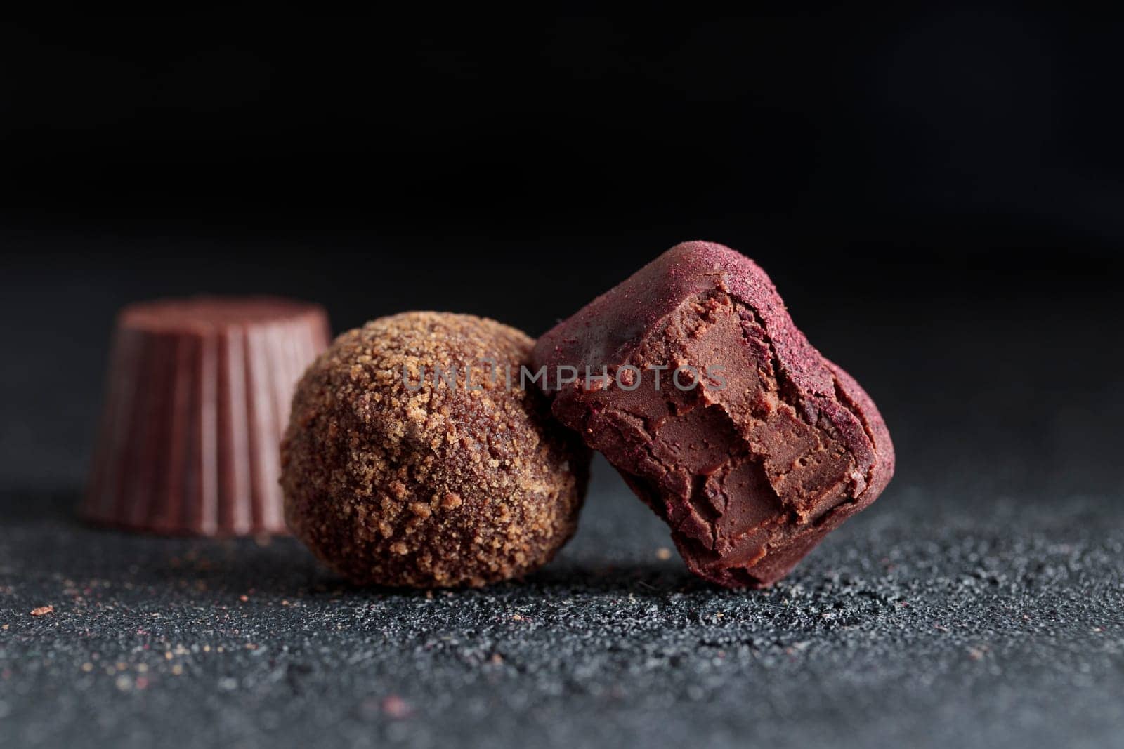 Premium gourmet chocolate handmade truffles from confectionery, homemade dark chocolate candies on black background