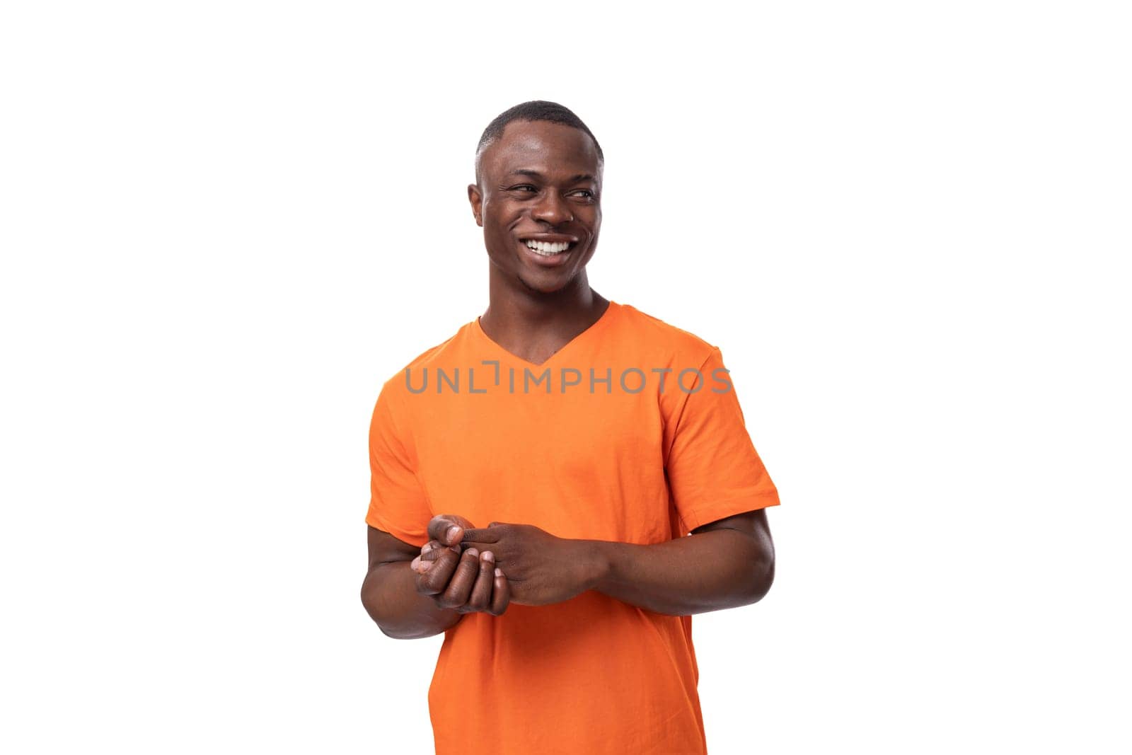 young charismatic positive American guy with a short haircut dressed in an orange T-shirt on a white background.