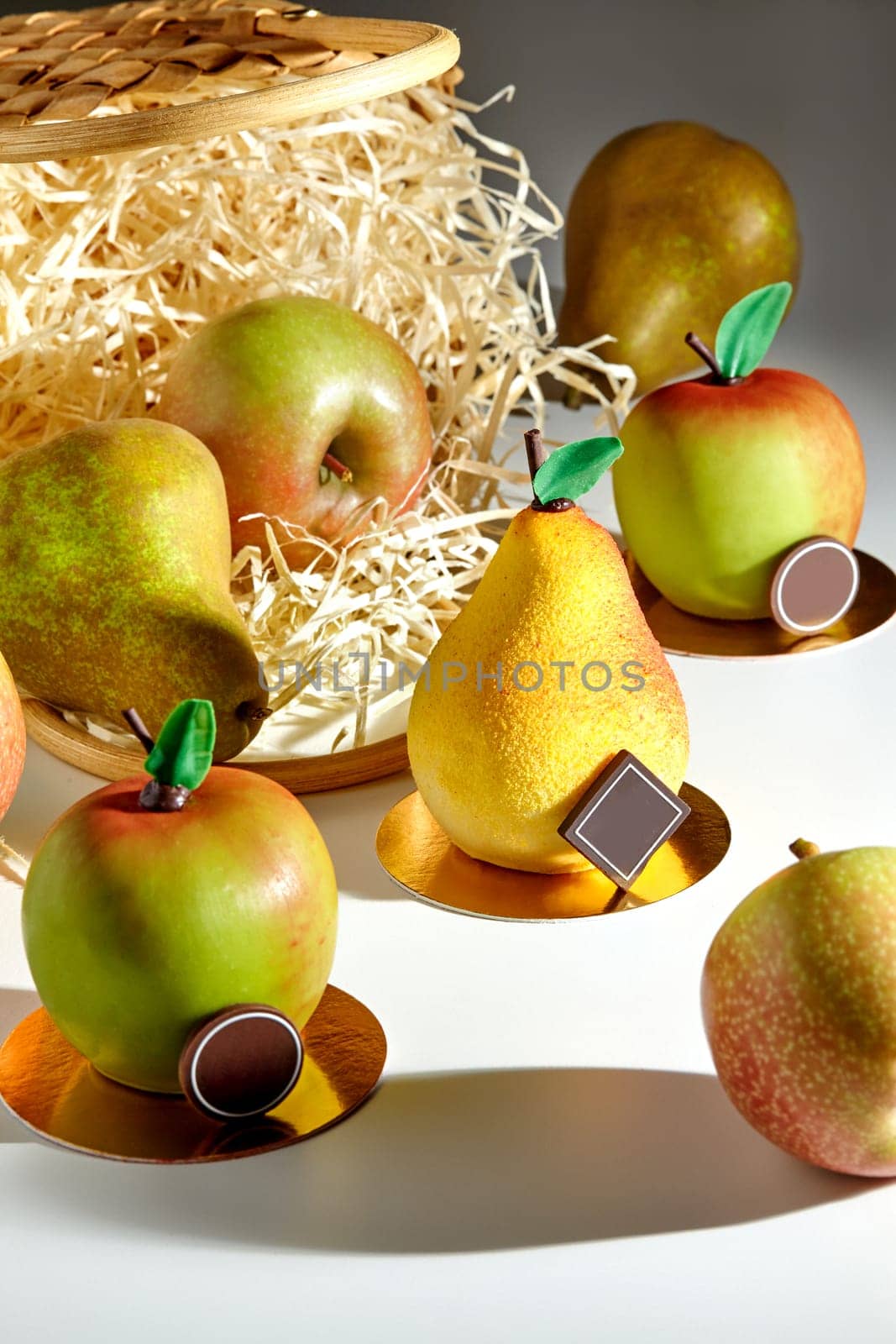 Desserts in shape of pear and apple with fresh fruits and straw basket by nazarovsergey