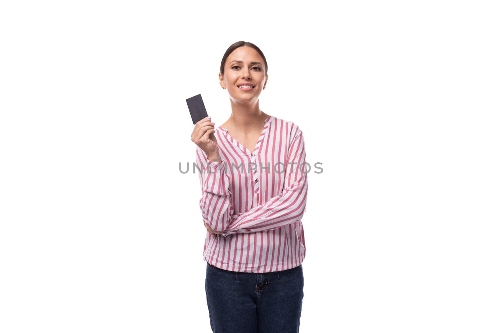 young brunette business woman dressed in a striped shirt shows a plastic credit card.