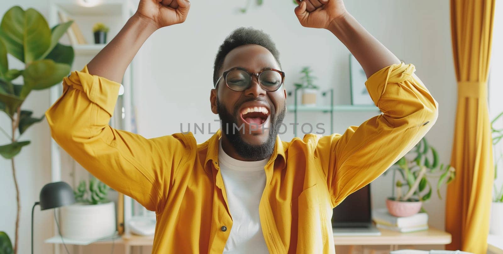 Happy overjoyed laughing african man celebrating success raising her hands up while working on laptop sitting at home office