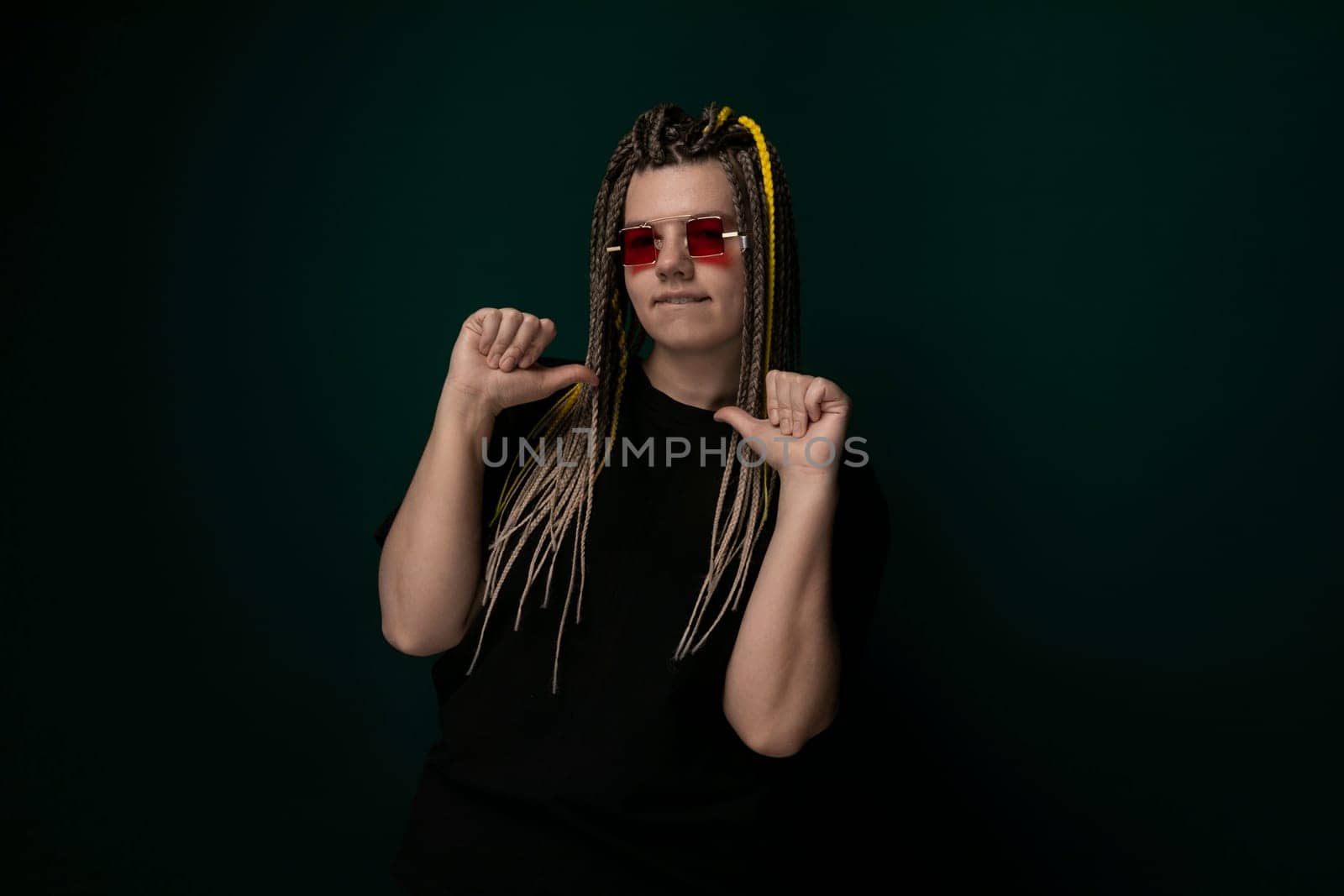 A woman with dreadlocks wearing red sunglasses is featured in this photo. She exudes confidence as she poses for the camera, showcasing her unique style and personality.