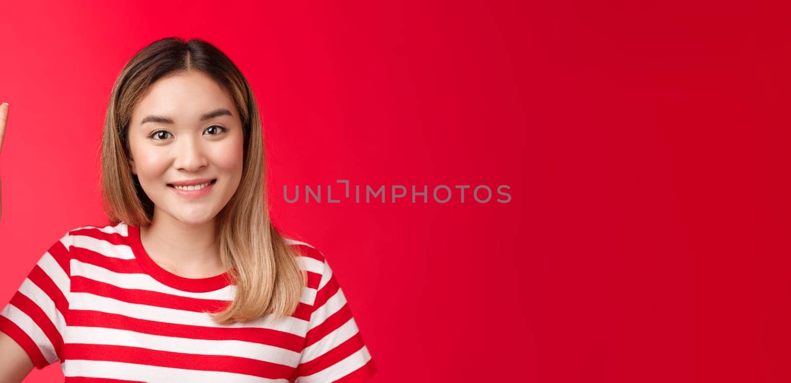 Close-up cheerful glad young attractive blond woman wear striped t-shirt smiling friendly make order, reservation for two show victory peace sign, stand red background, wanna be second by Benzoix