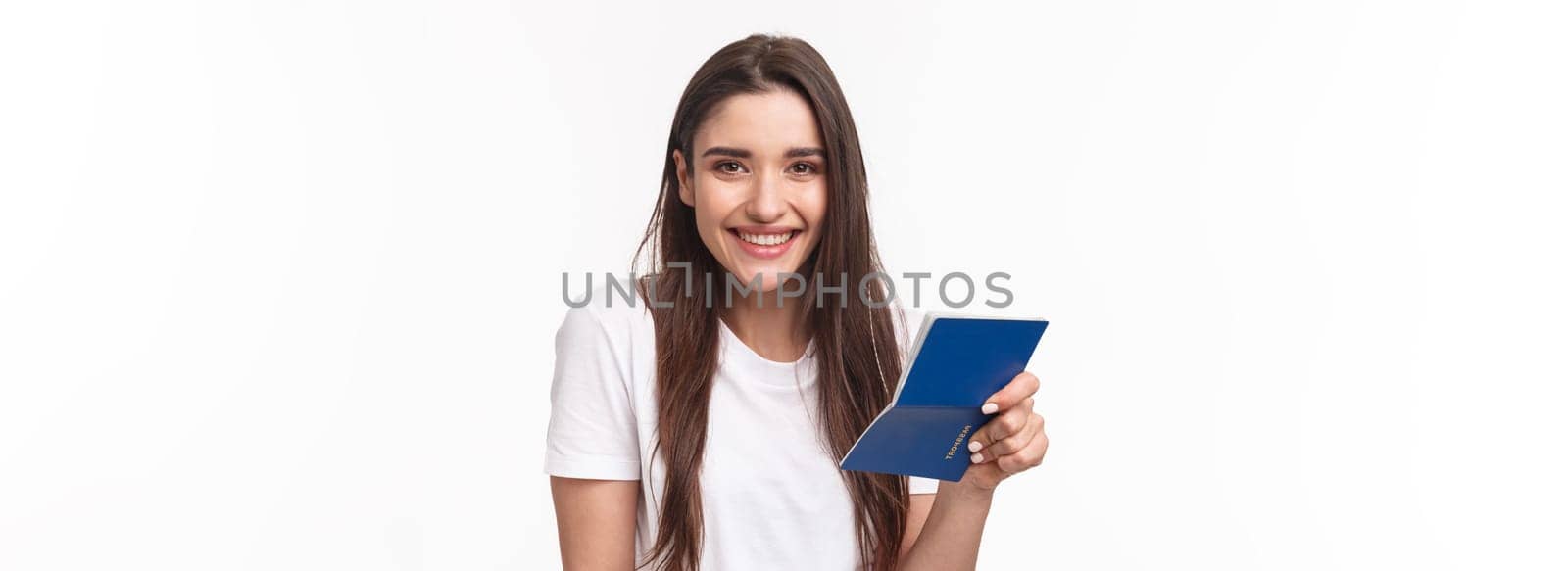 Travelling, holidays, summer concept. Close-up portrait of cute, happy pretty young woman in t-shirt, holding opened passport and smiling, standing in airport terminal going for journey, vacation.