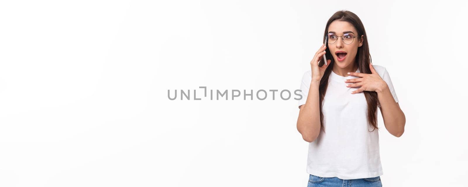 Communication, technology and lifestyle concept. Portrait of excited and surprised, overwhelmed young cute girl receive incredible news, gasping and touching heart as talking on phone, winning by Benzoix