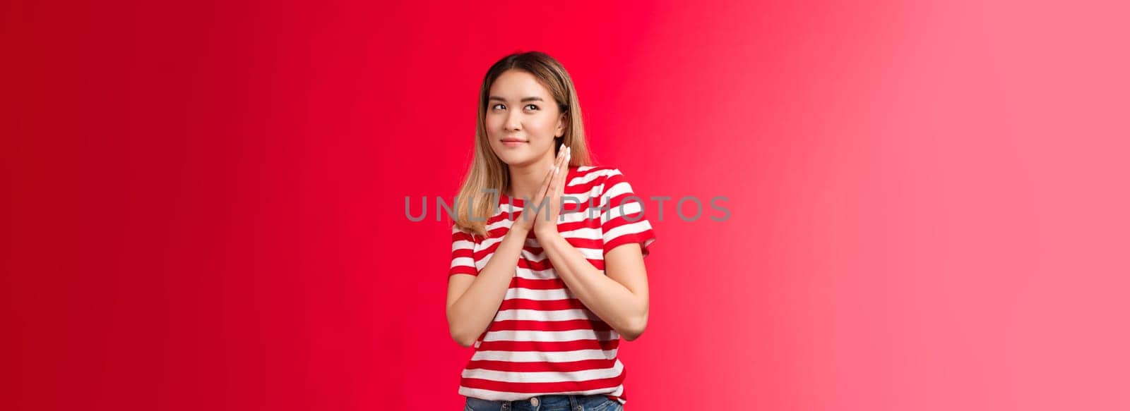 Smart and creative good-looking blond asian girl rubbing palms together devious and cunning have perfect plan, woman smirking curiously look up scheming have idea, stand red background.