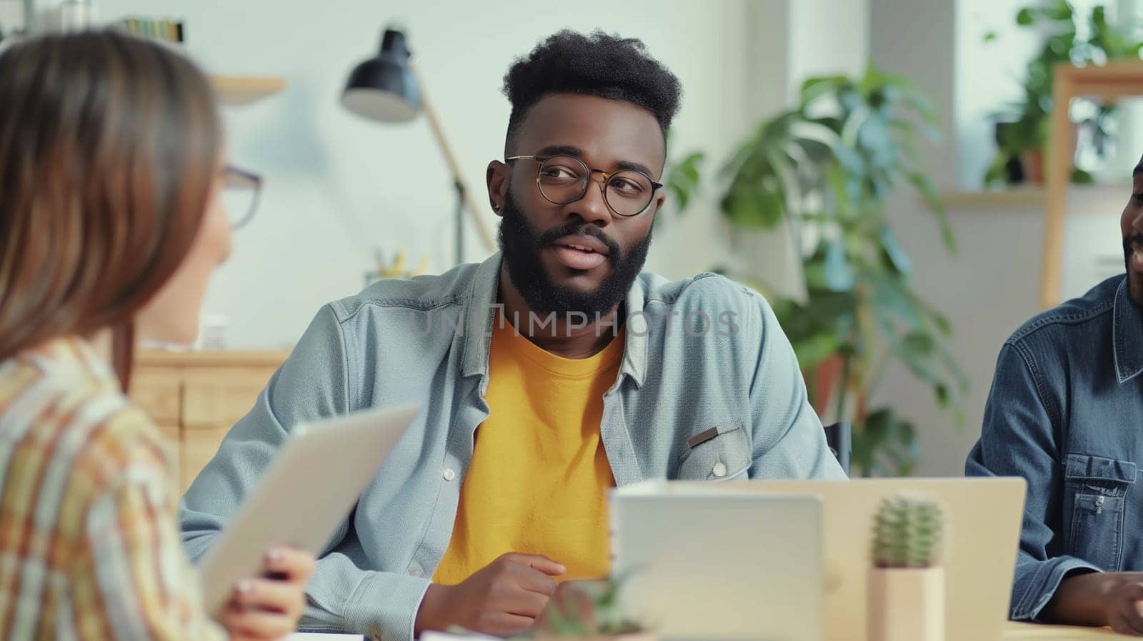 Modern black young man, business people discussing a new project together sitting at the desk in an office, african colleagues having a conversation at a meeting