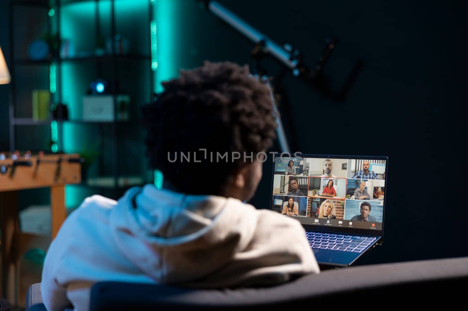Management executive holding video conference meeting with remotely working multiethnic team. Manager teleworking in stylish welcoming apartment, discussing with workers during internet video call