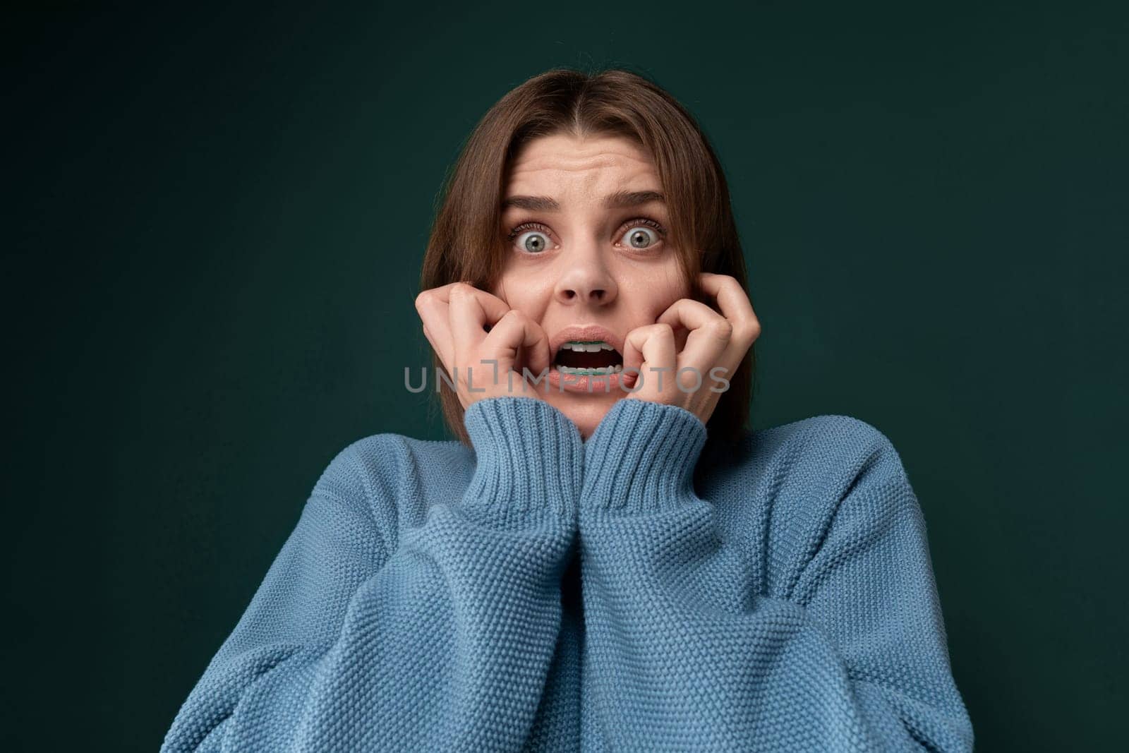 A middle-aged woman with dark hair and a surprised expression on her face, eyebrows raised and mouth slightly open. Her eyes are wide and expressive, showing astonishment or shock.