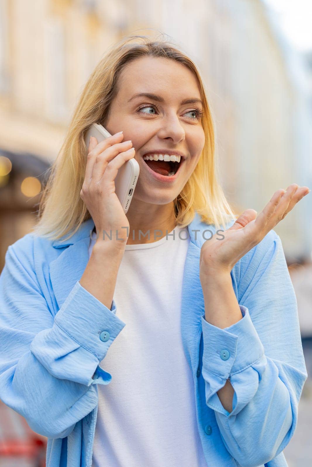 Caucasian woman tourist having remote conversation communicate speaking by smartphone with friend, talking on phone unexpected good news gossip walking on urban city street. Town lifestyles outdoors