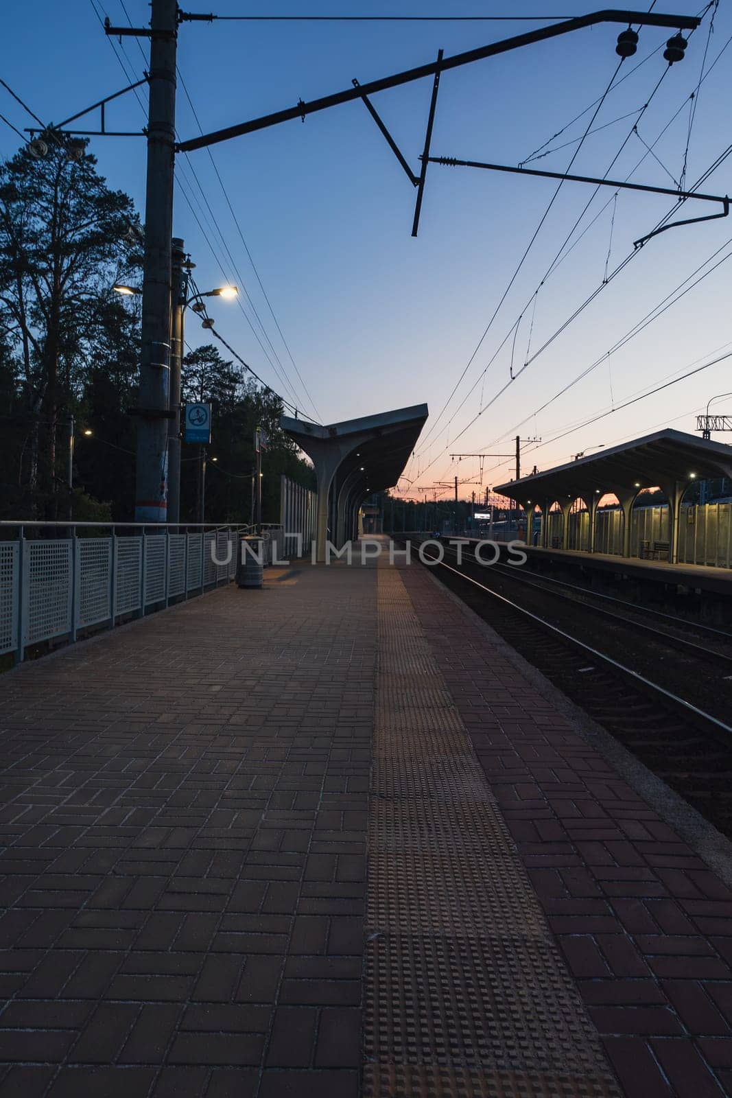 A beautiful railway station in the rays of a colorful sunset. Taking a picture using a wide-angle lens. High quality photo