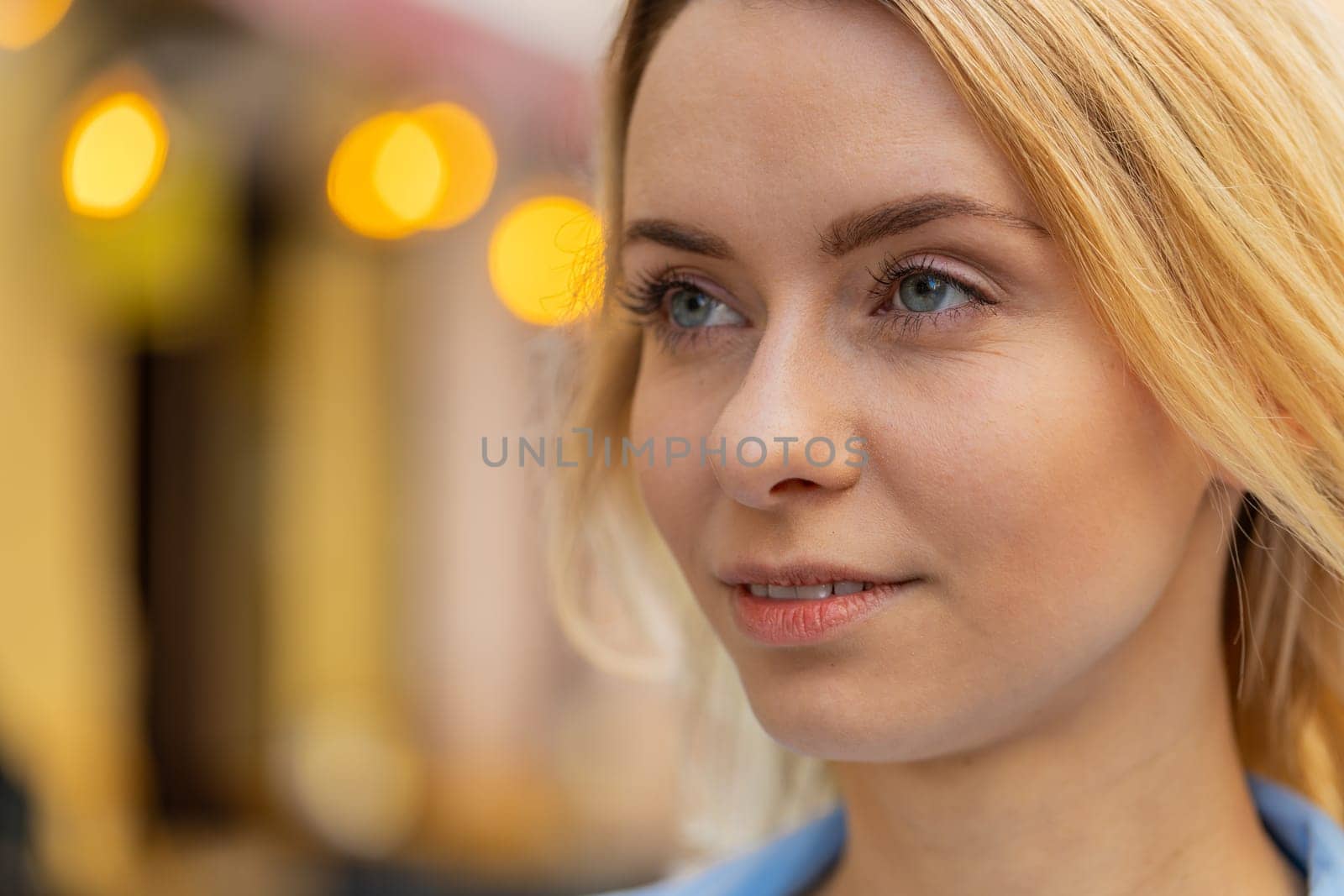 Close-up portrait of happy young blonde woman face smiling friendly open eyes glad expression looking dreaming resting relaxation feel satisfied good news outdoors. Pretty adult lady on city street