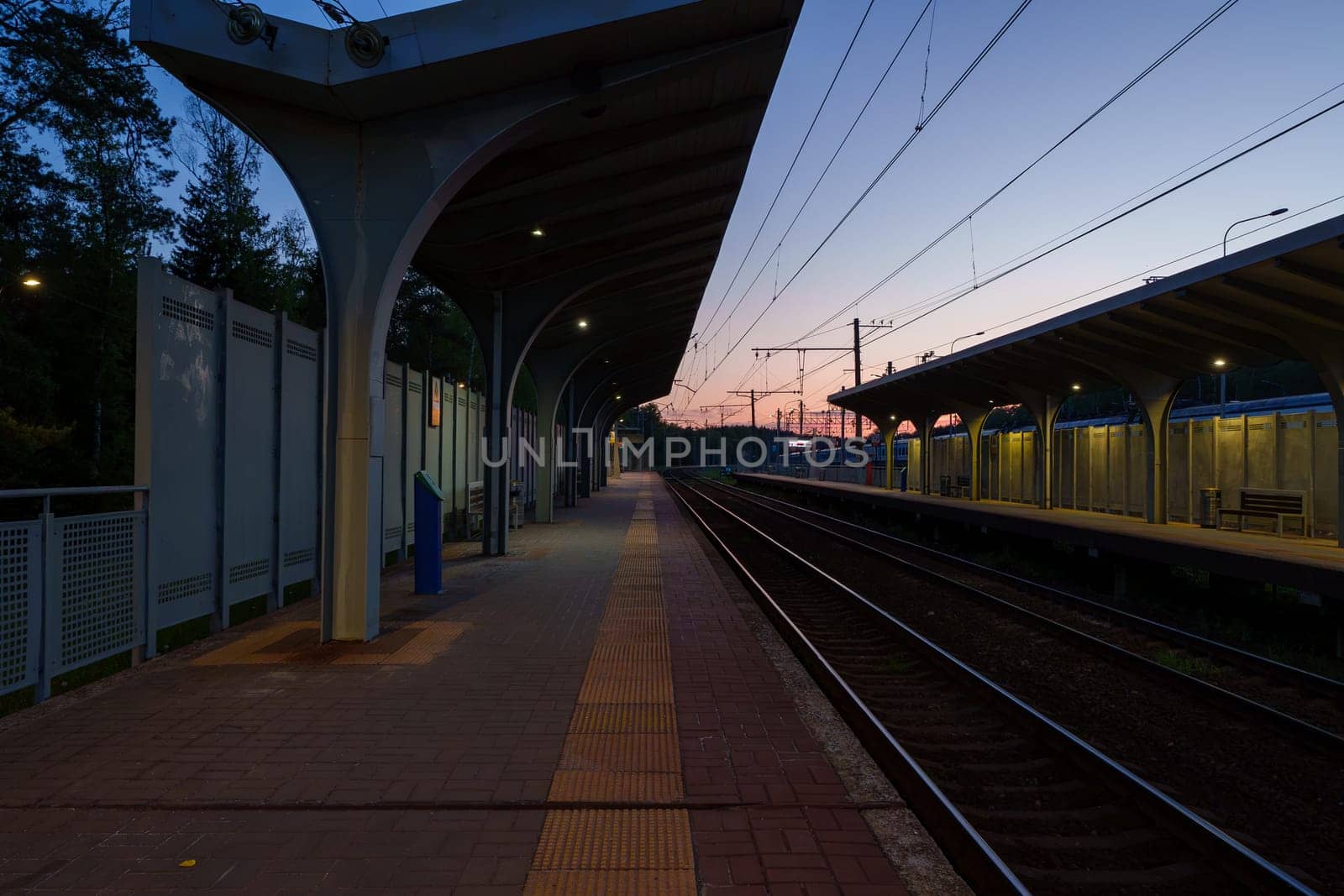 A beautiful railway station in the rays of a colorful sunset. Taking a picture using a wide-angle lens. High quality photo